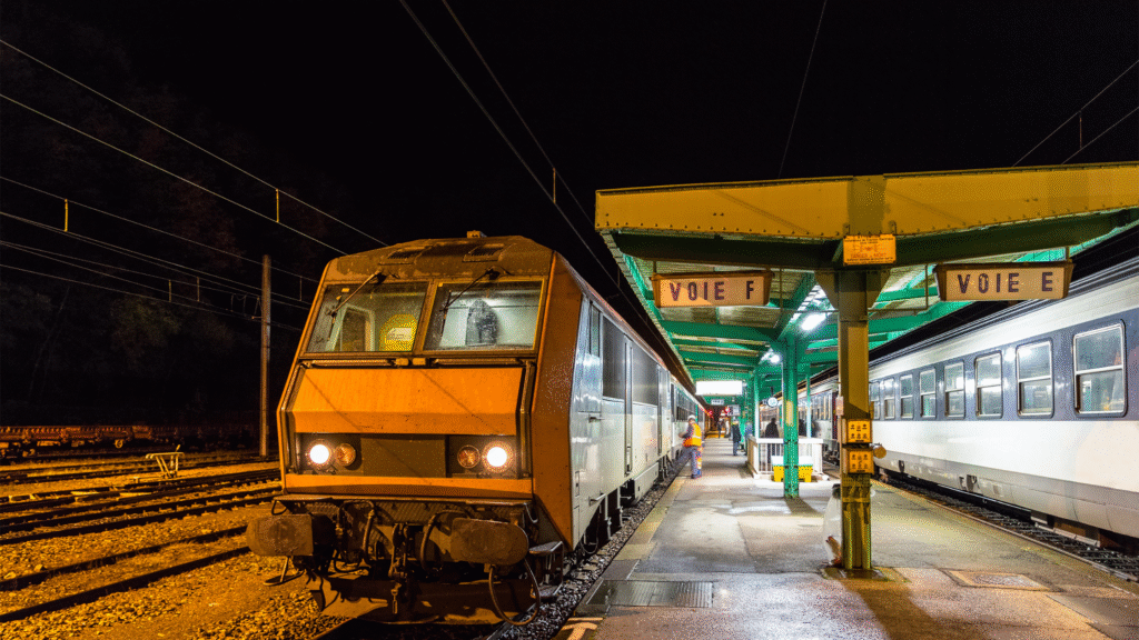night trains Europe 2025 sleeper train arriving at a European station at dawn