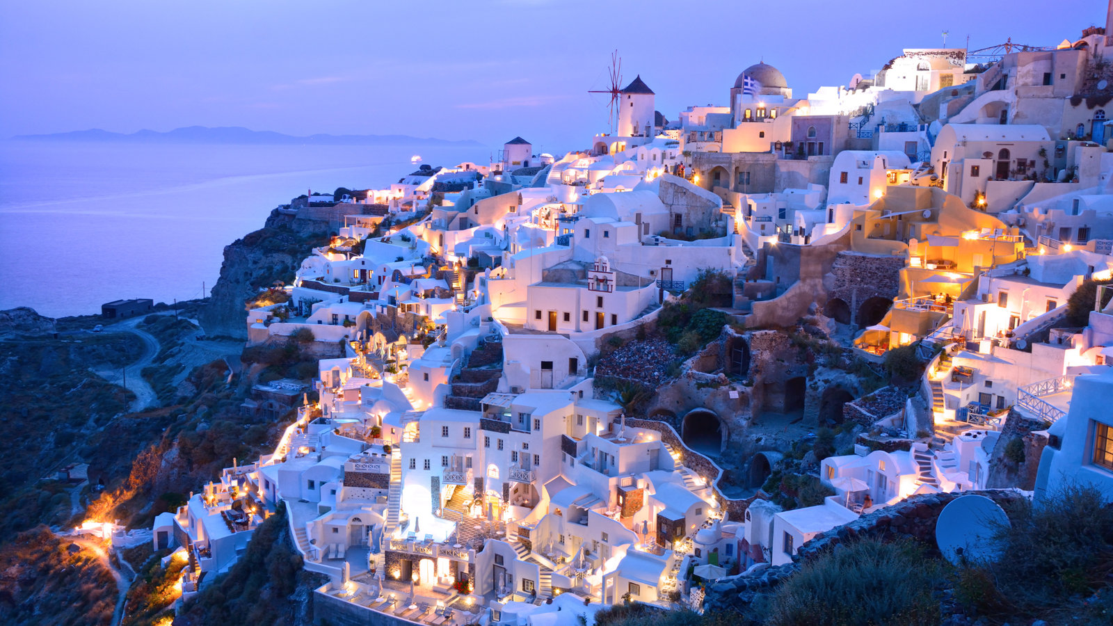 Santorini sunset over the Aegean Sea with whitewashed houses and blue domes
