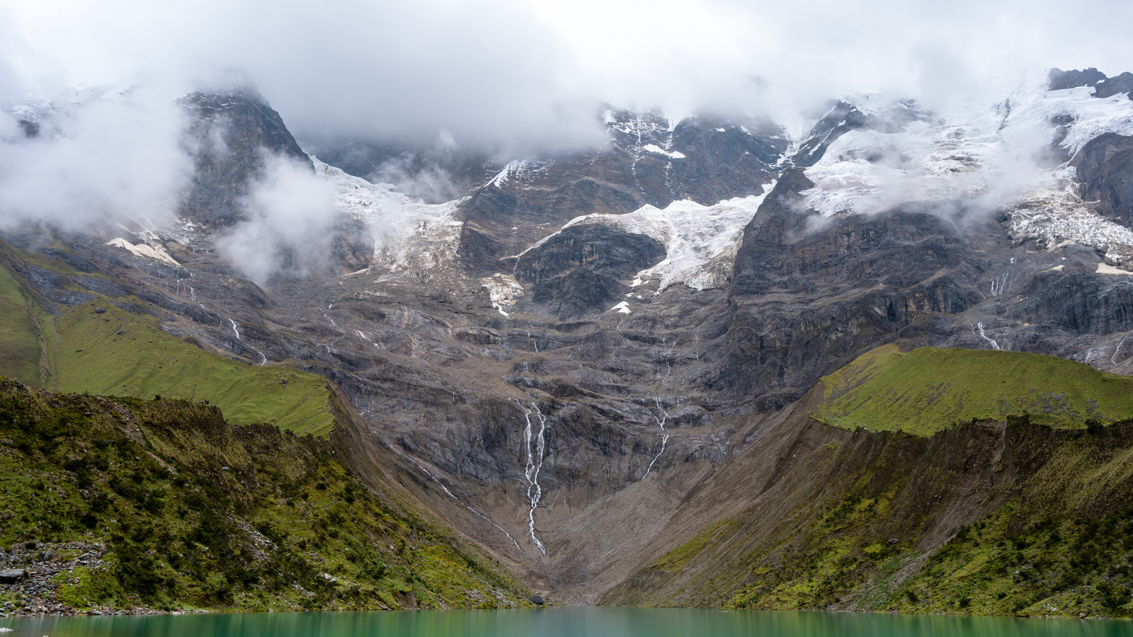 Serene mountain lake surrounded by misty peaks — symbol of mental clarity through sustainable travel 2025