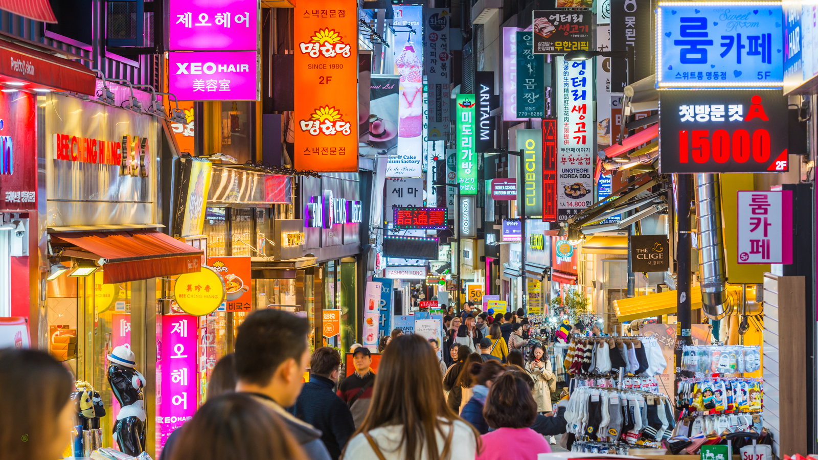 Crowded Seoul street filled with tourists and neon signs — symbol of modern mass tourism 2025