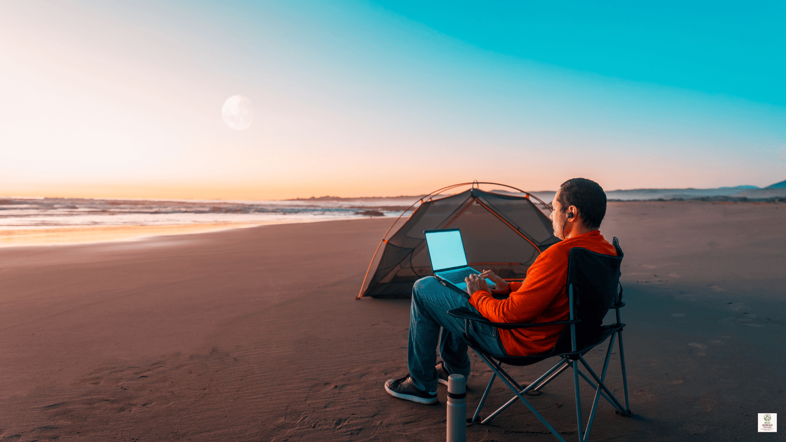 Digital nomad working on a laptop at sunset on a quiet beach, representing sustainable remote work in 2025.