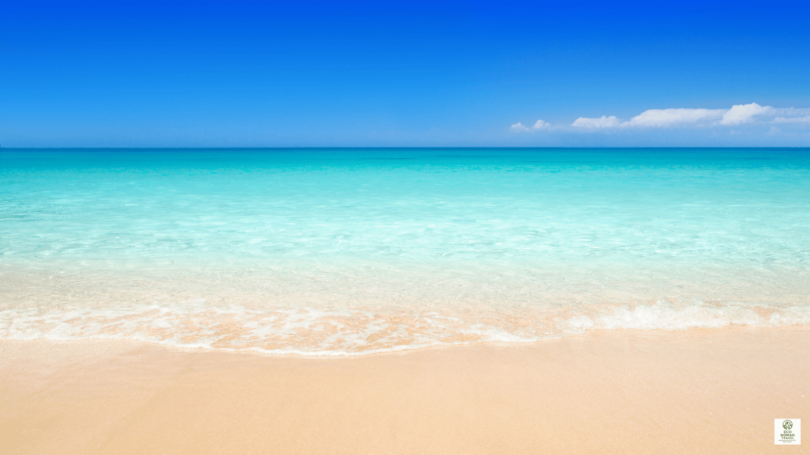 Wide view of a beautiful sandy beach and turquoise water, representing low-impact coastal travel choices