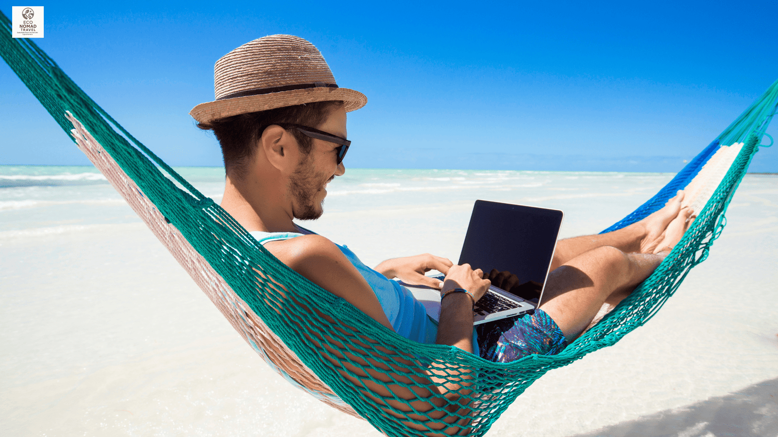 Digital nomad lying on a sandy beach working on a laptop — eco-friendly remote work lifestyle 2025