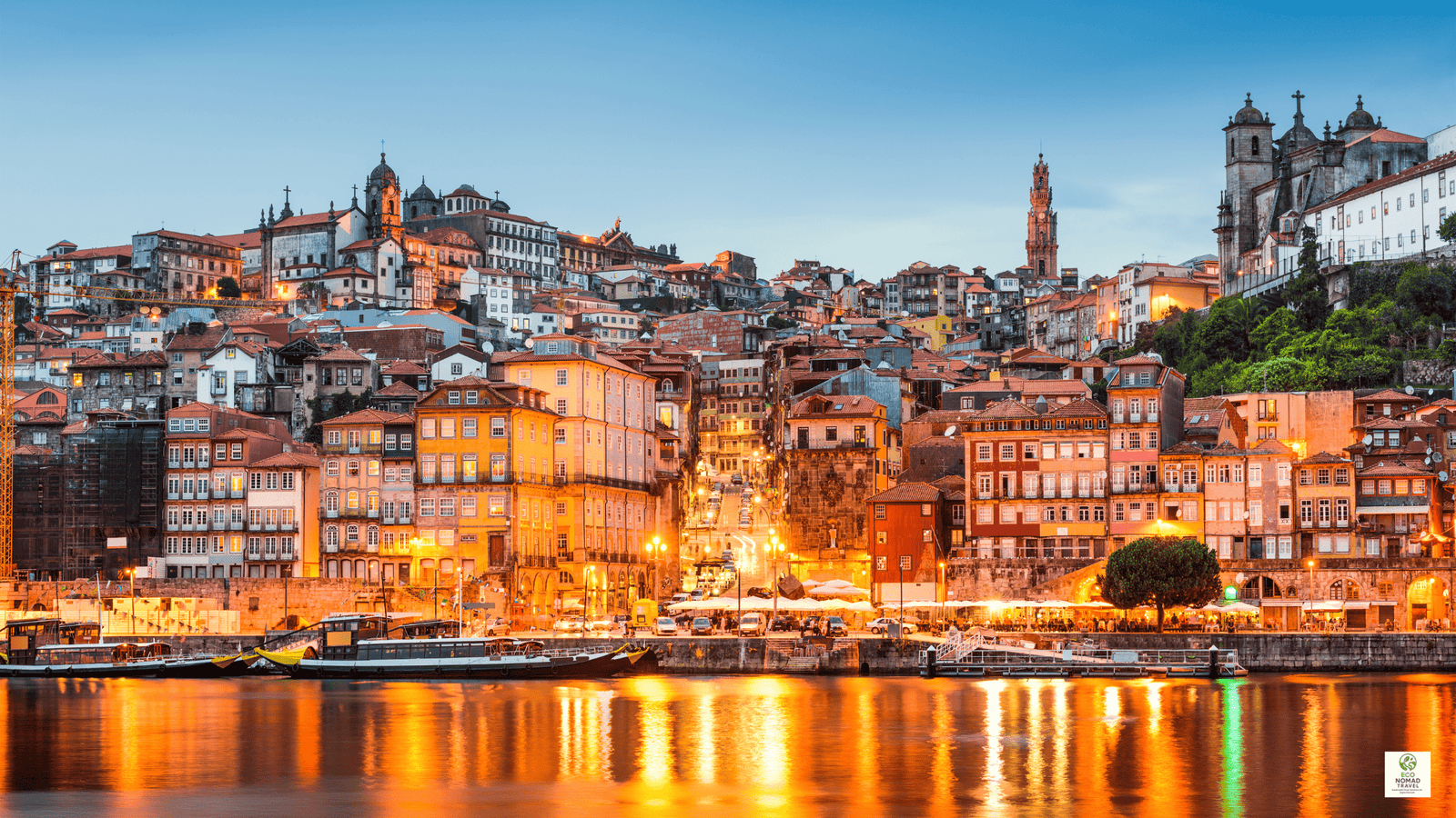 Sunset over the Douro River in Porto, Portugal, with historic houses and boats, illustrating a scenic stop on a rail-first flight-free travel itinerary in 2025