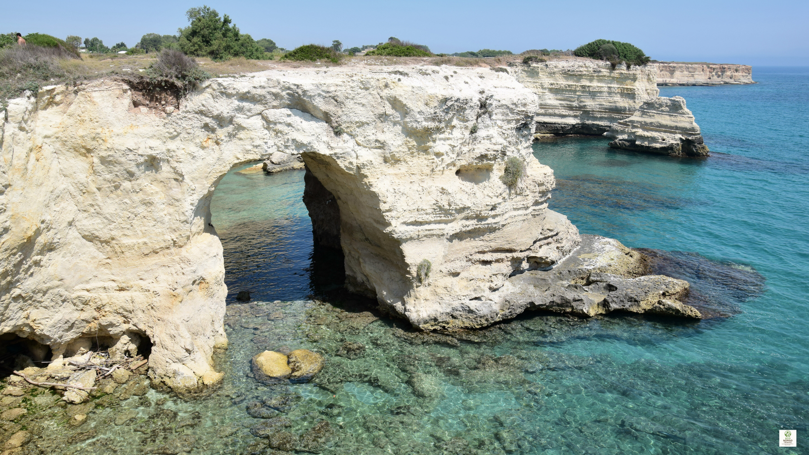 Adriatic coastline with a rocky sea tunnel cut through the rock above clear water