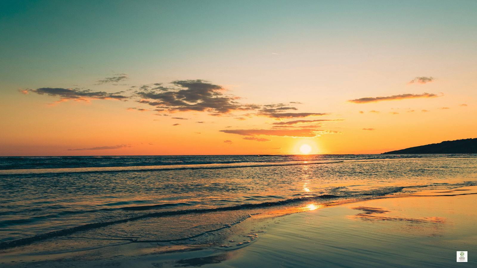 Adriatic Sea at sunset with golden light over calm water and a coastal town shoreline