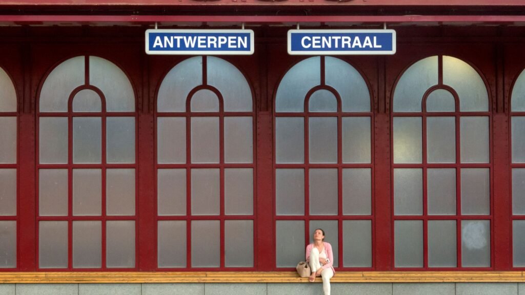 Traveler waiting on a platform at Antwerp Central Station for the Belgium train travel guide.
