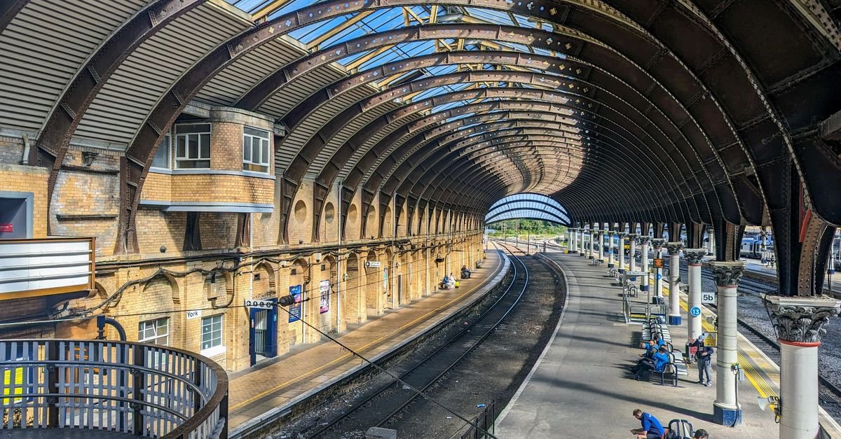A Victorian railway station roof over busy platforms